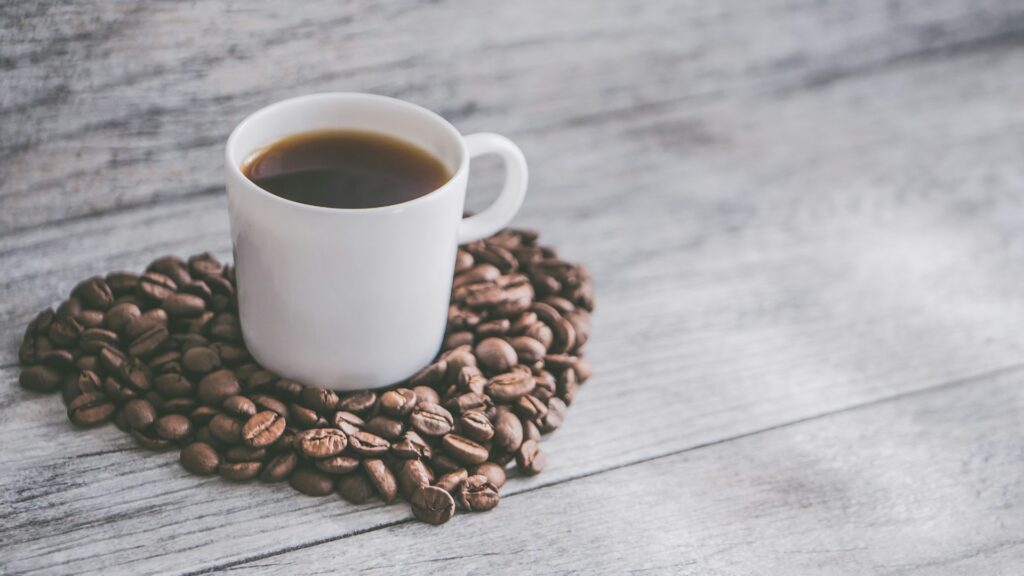 Witte koffiemok op een hartvorm van koffiebonen, perfect passend bij Nationale koffiedag