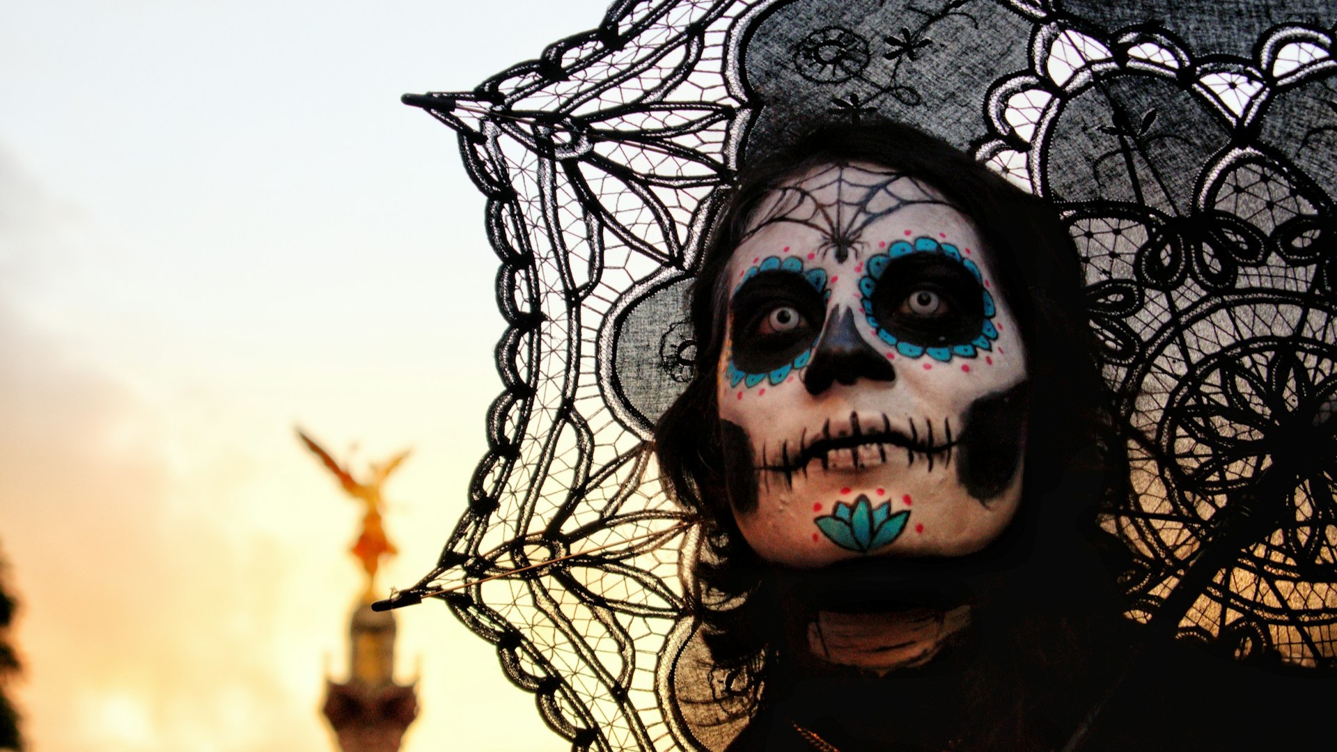 Vrouw met calavera schmink en zwarte sluier tijdens Dag van de Doden tradities bij zonsondergang