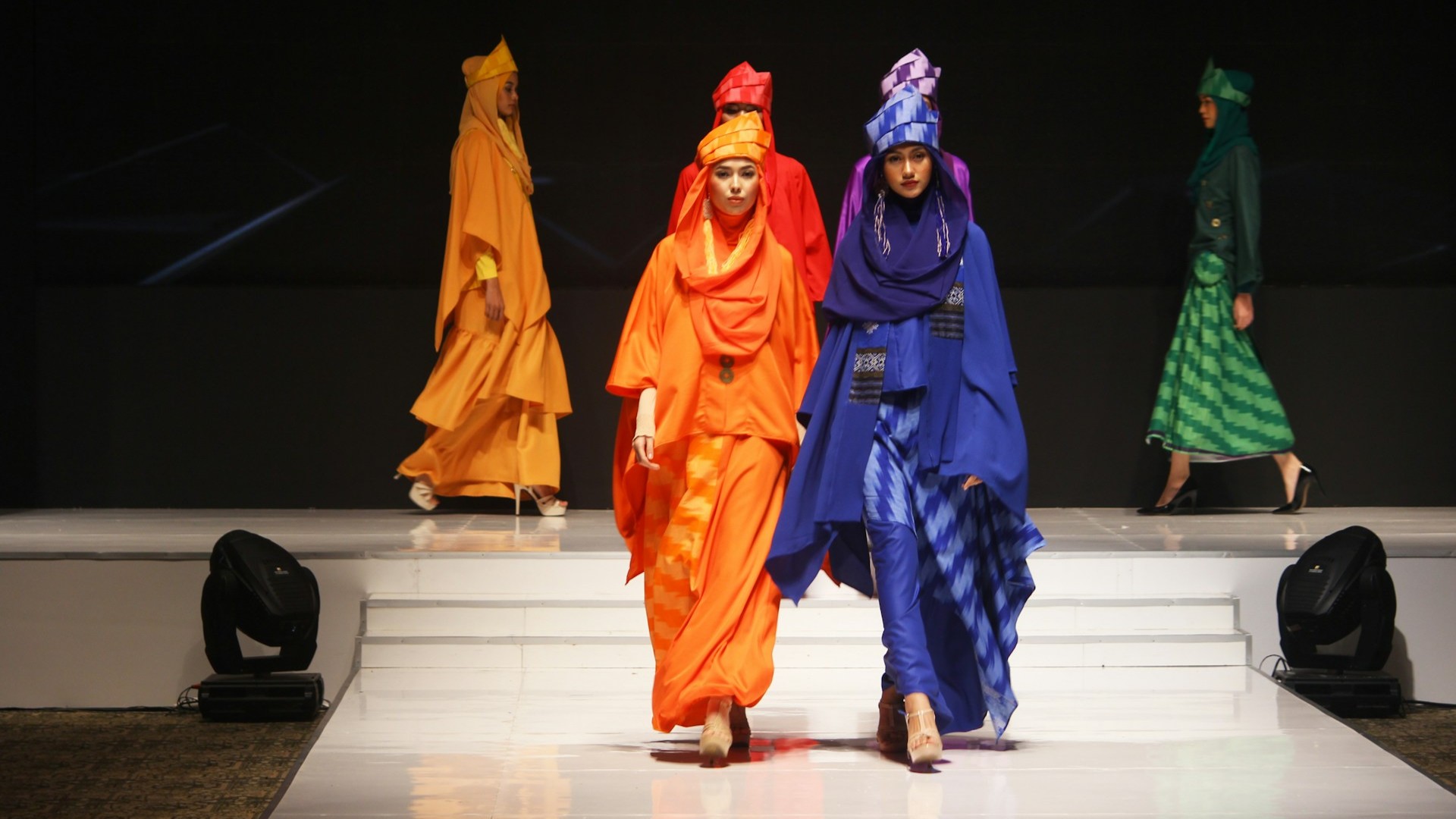 Modellen in kleurrijke outfits op de catwalk tijdens Paris Fashion Week