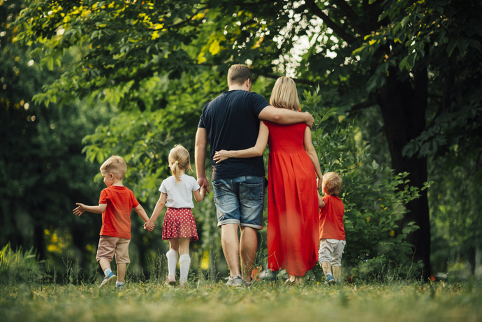 Gezin met kinderen wandelt samen door het park tijdens de Internationale Dag van het Gezin.